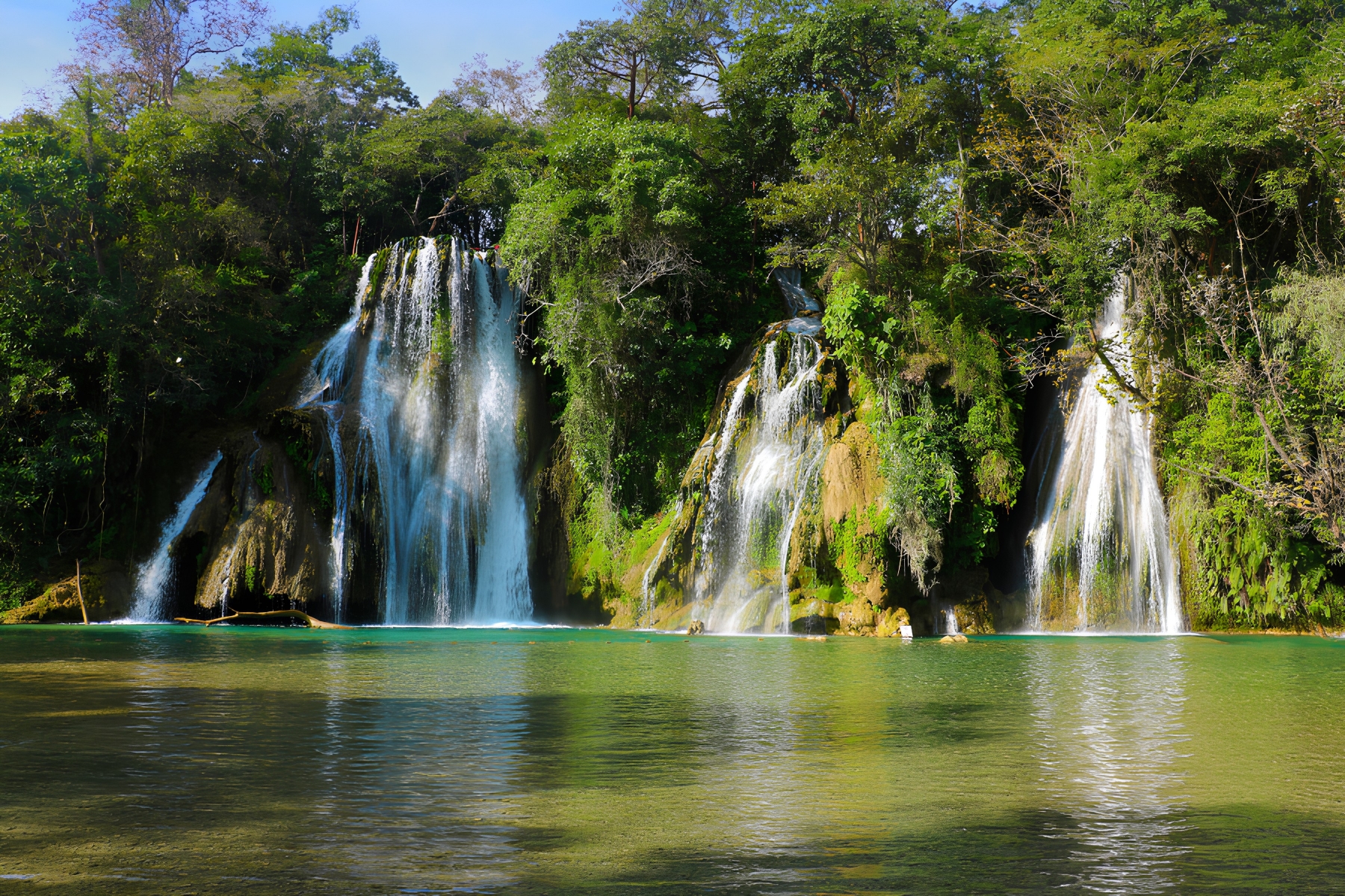 Cascadas cayendo sobre pozas naturales turquesa
